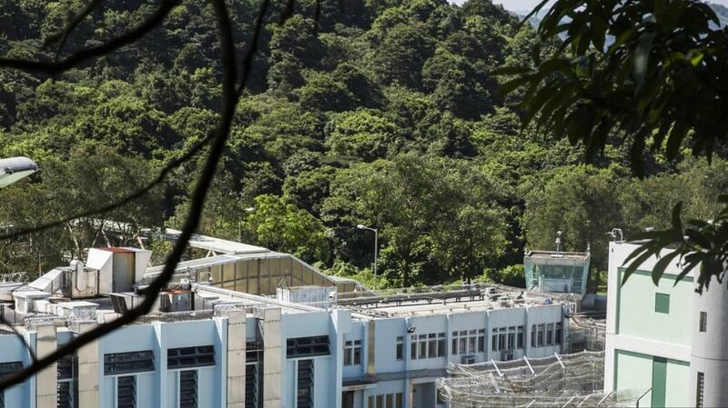 透过外墙,可看见壁屋惩教所内的建筑物。张梓轩(化名)曾透过日间活动室旁的天井,往下探头看见因被判入教导所而羁押在壁屋惩教所的青少年,被要求正午于操场上晒热的水沟盖上做伏地挺身。(摄影/AFP/ISAAC LAWRENCE)